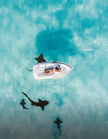 Man laying on a floating bed in the sea Man laying on a floating bed in the sea