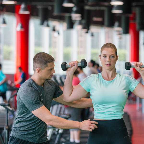 personal trainer coaching on dumbbells lifting